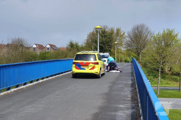 Man en vrouw gaan met scooter onderuit op fietsbrug