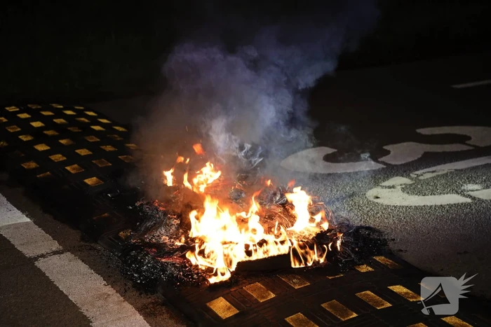 Brandweer blust brandende band op midden van weg
