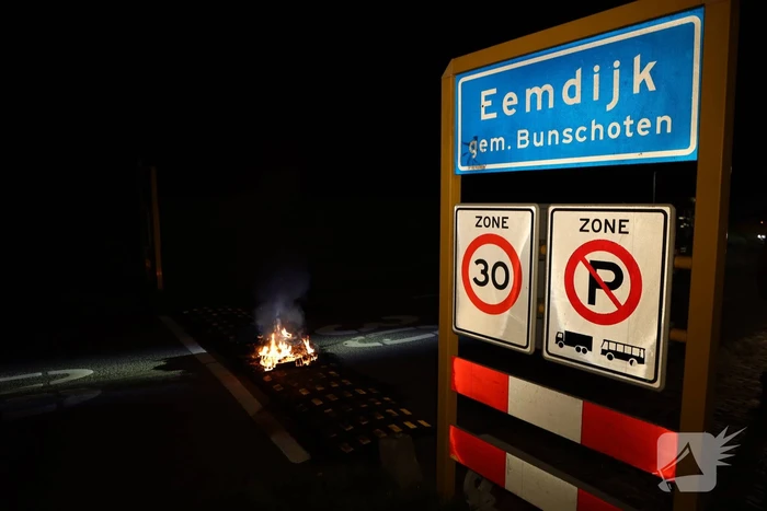 Brandweer blust brandende band op midden van weg