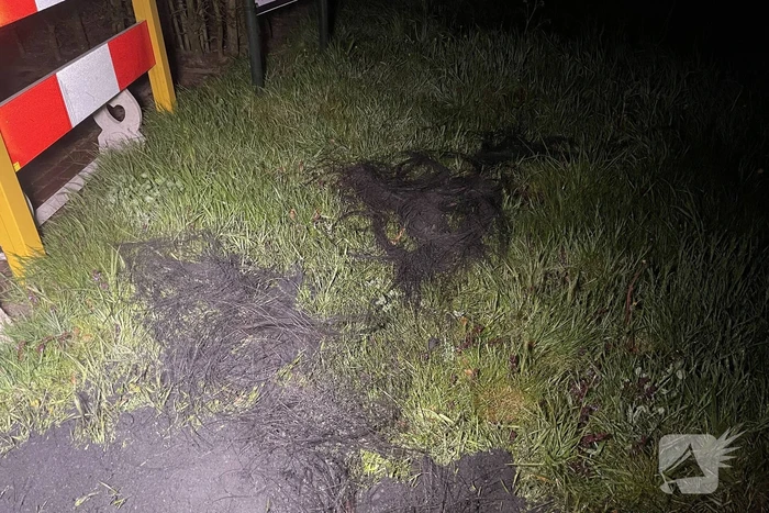 Brandweer blust brandende band op midden van weg