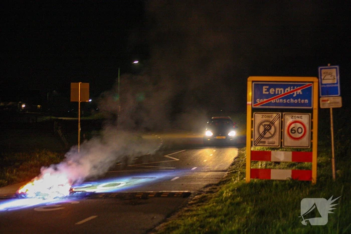 Brandweer blust brandende band op midden van weg