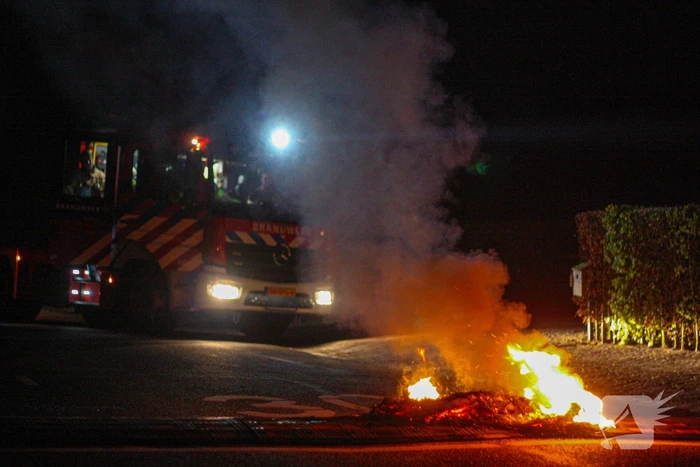 Brandweer blust brandende band op midden van weg