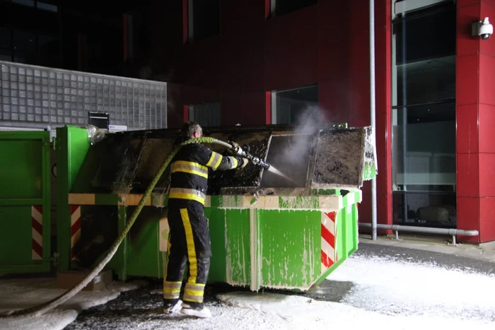 Bouwcontainer vol papier vat vlam