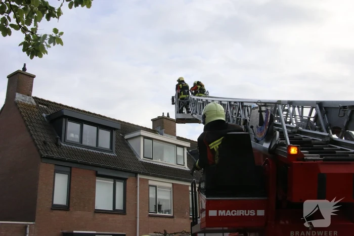 Brandweer legt weggewaaide dakpannen terug