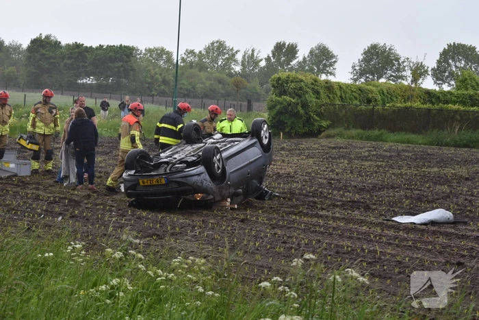 Auto op z'n kop in weiland