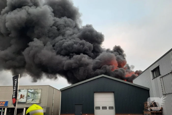 Dikke zwarte rookwolken bij uitslaande brand