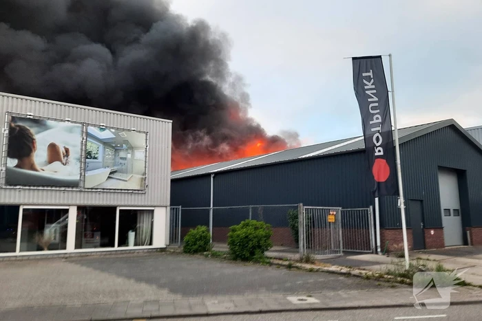 Dikke zwarte rookwolken bij uitslaande brand