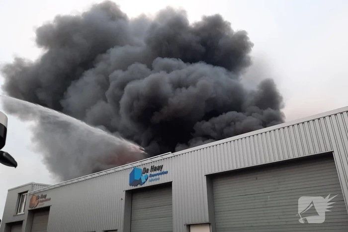 Dikke zwarte rookwolken bij uitslaande brand