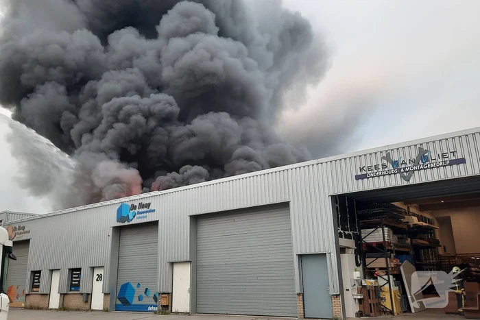Dikke zwarte rookwolken bij uitslaande brand