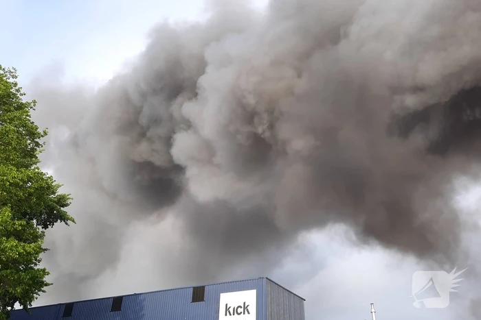 Dikke zwarte rookwolken bij uitslaande brand