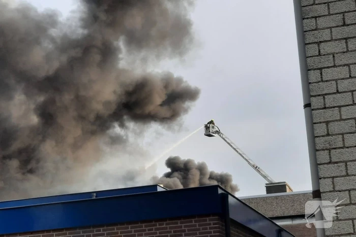 Dikke zwarte rookwolken bij uitslaande brand