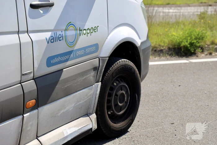Auto botst op taxibus op rotonde