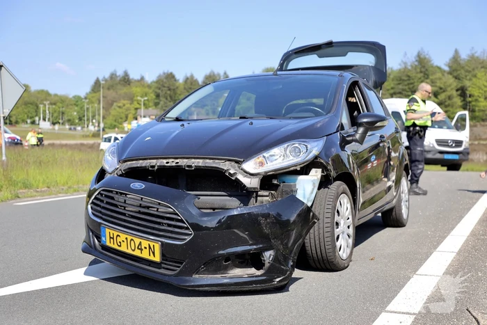 Auto botst op taxibus op rotonde