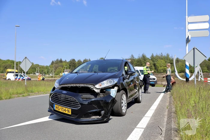 Auto botst op taxibus op rotonde