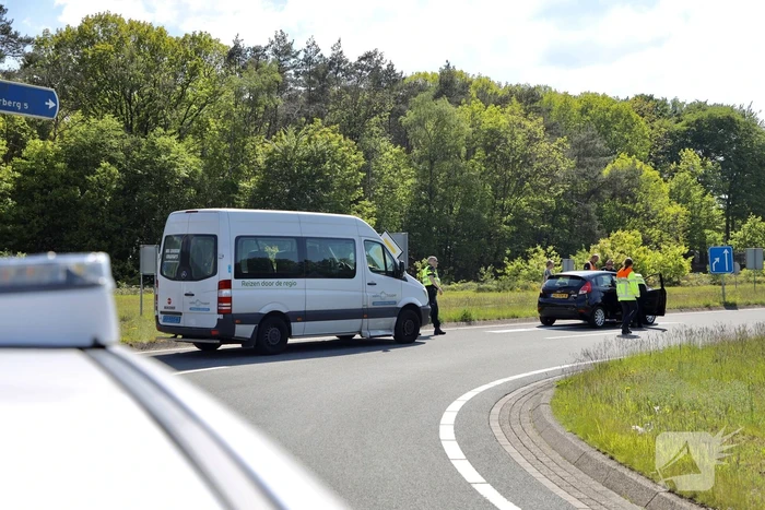 Auto botst op taxibus op rotonde