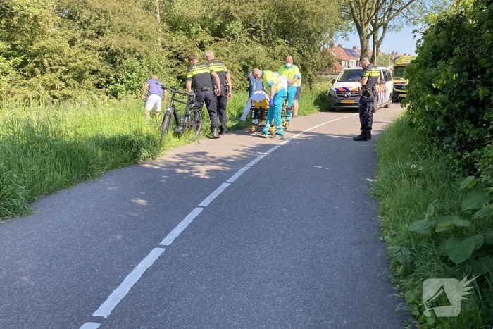 Vrouw gaat met fiets onderuit