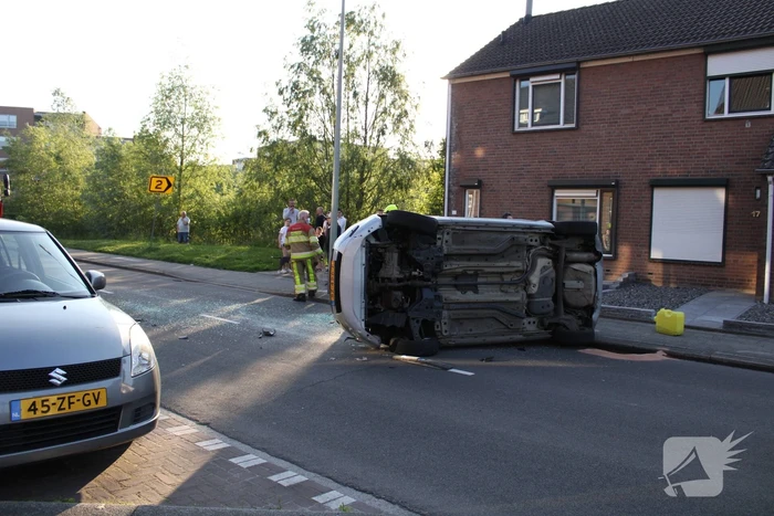 Auto op zijn kant na botsing