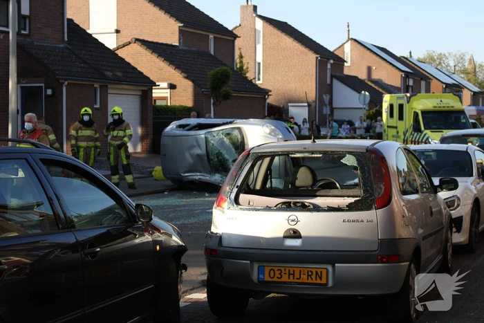 Auto op zijn kant na botsing