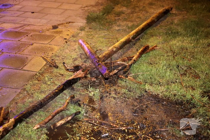 Brandweer blust brandende stukken hout