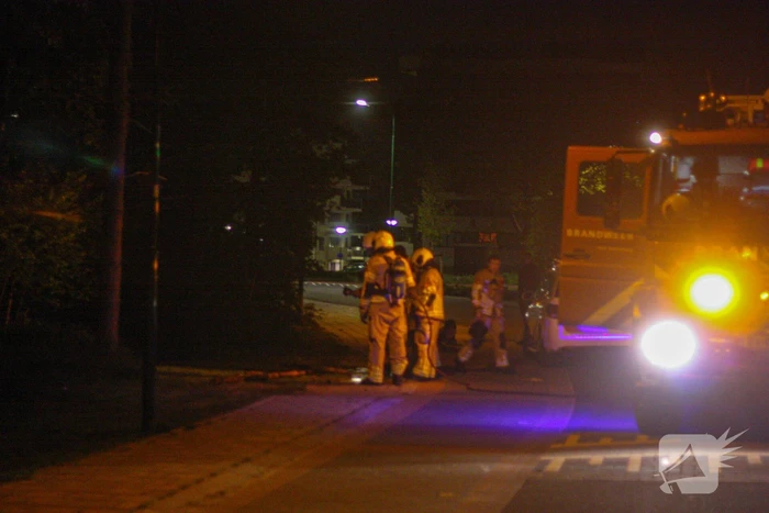 Brandweer blust brandende stukken hout