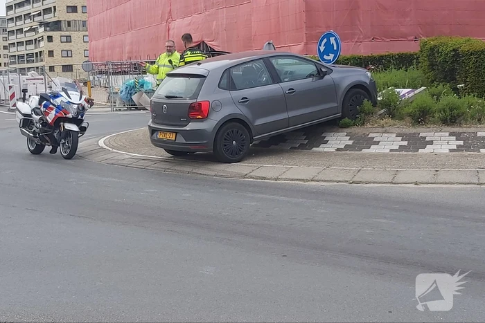 Automobilist rijdt met auto de rotonde op
