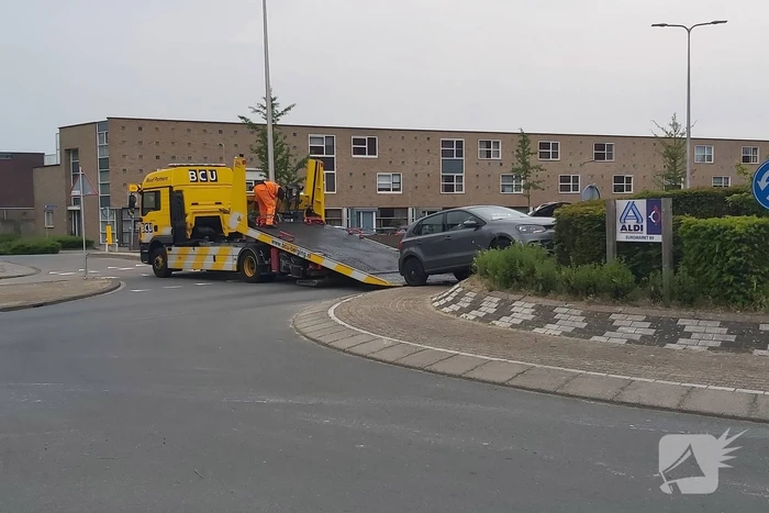 Automobilist rijdt met auto de rotonde op