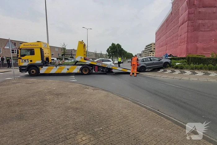 Automobilist rijdt met auto de rotonde op