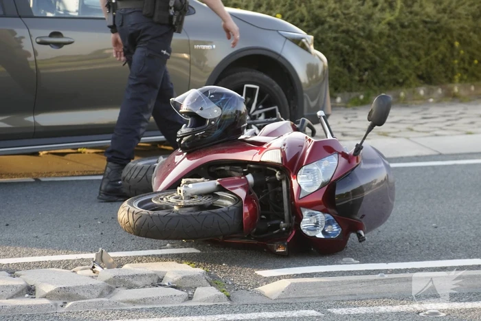Personenauto en motor botsen op rotonde