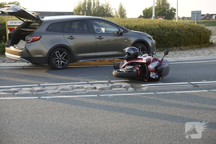 Personenauto en motor botsen op rotonde