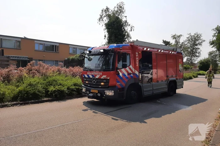 Brandweer blust in brand staande schutting