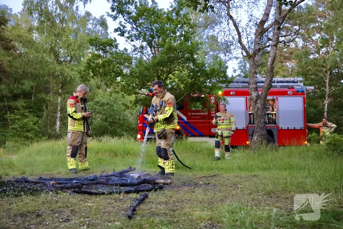 Stapel houten takken in brand in bosgebied De Bergjes