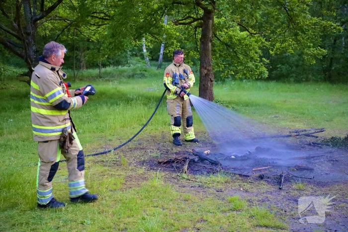 Stapel houten takken in brand in bosgebied De Bergjes