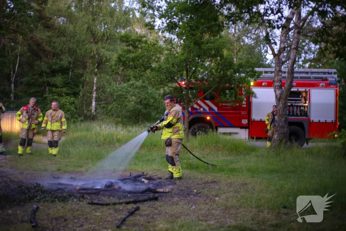 Stapel houten takken in brand in bosgebied De Bergjes