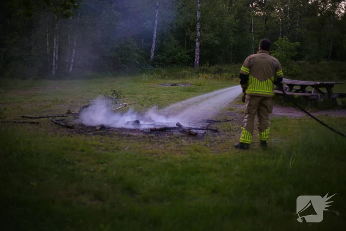 Stapel houten takken in brand in bosgebied De Bergjes