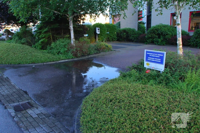 Waterlekkage op parkeerplaats van bedrijf