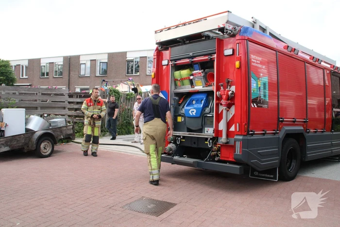 Brandweer blust in brand gestoken container