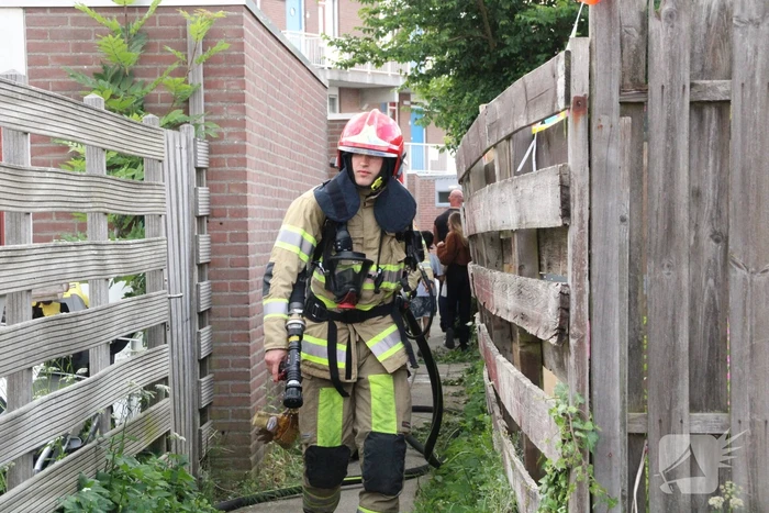 Brandweer blust in brand gestoken container