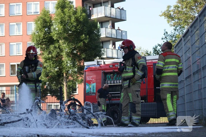 Brandweer blust brandende stapel fietsen
