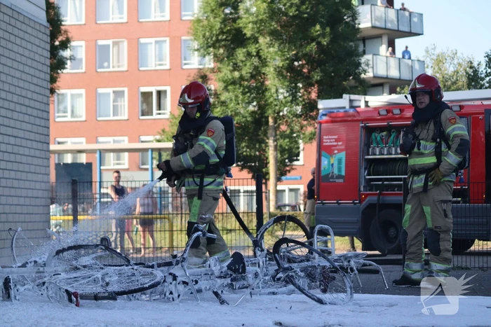 Brandweer blust brandende stapel fietsen