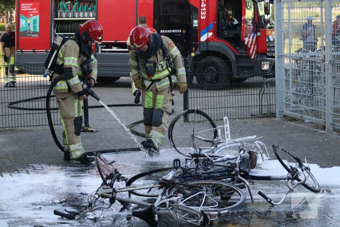 Brandweer blust brandende stapel fietsen