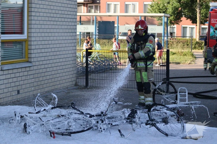 Brandweer blust brandende stapel fietsen