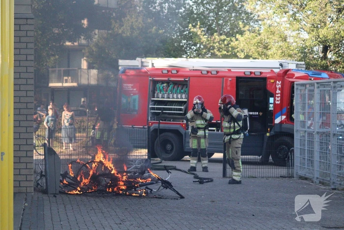 Brandweer blust brandende stapel fietsen