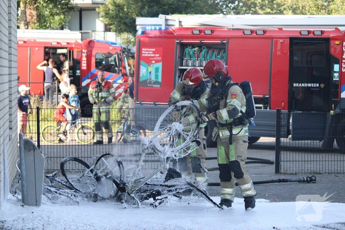 Brandweer blust brandende stapel fietsen