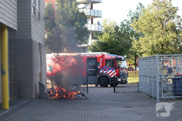 Brandweer blust brandende stapel fietsen
