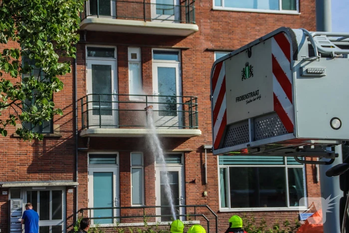Brandweer blust brandende plant op balkon