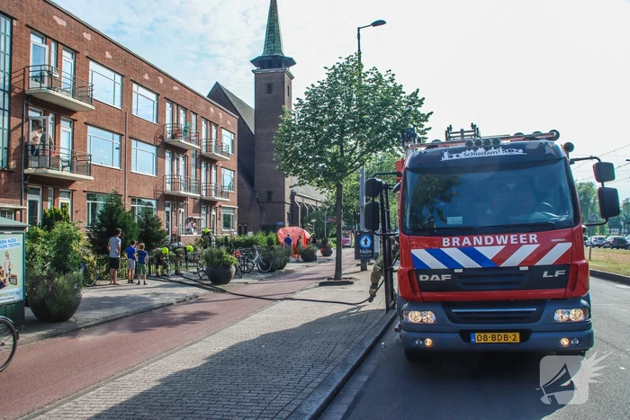 Brandweer blust brandende plant op balkon