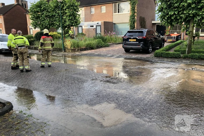 Straat onder water door gesprongen waterleiding