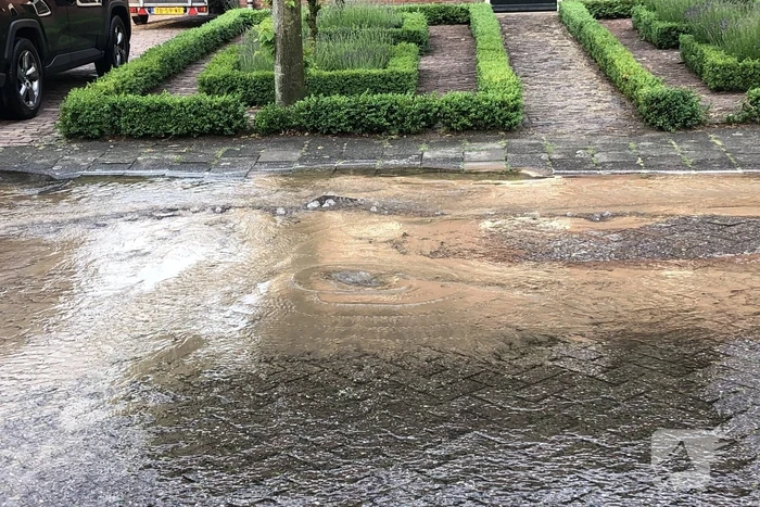 Straat onder water door gesprongen waterleiding