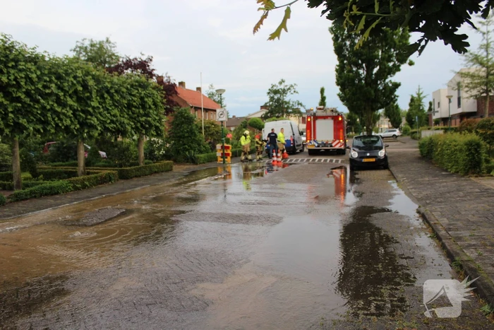 Straat onder water door gesprongen waterleiding