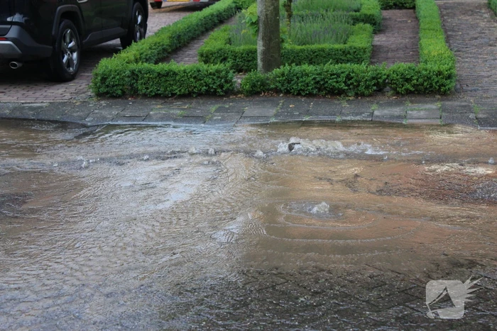 Straat onder water door gesprongen waterleiding